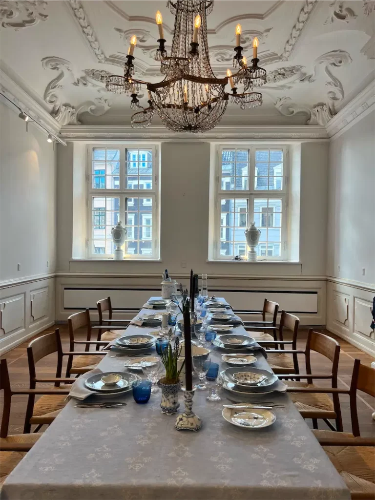 Sala w Designmuseum Danmark z nakryciem stołu i kryształowym żyrandolem